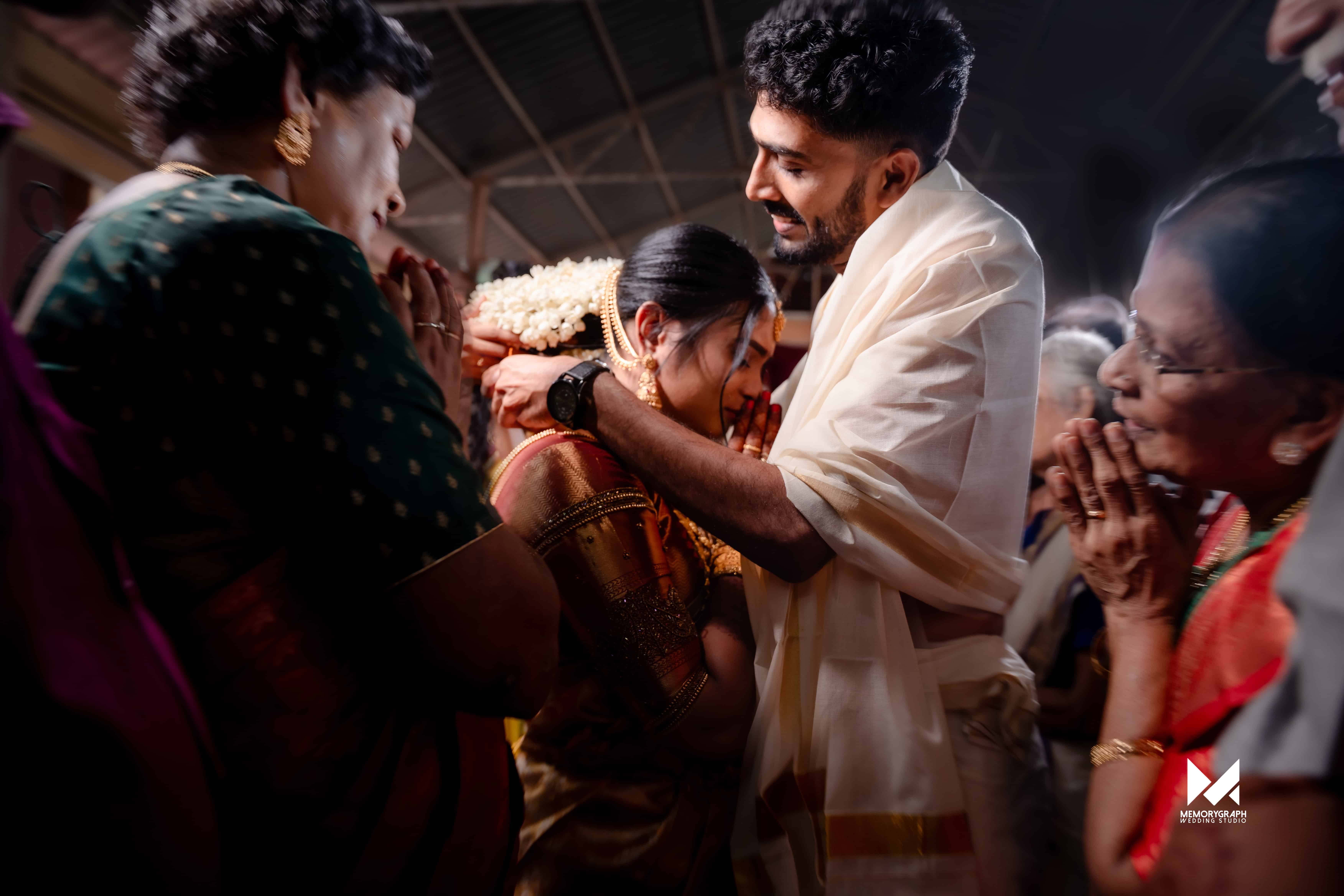 Bride and groom framed in warm temple light during a Kerala wedding